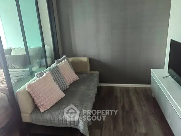 Modern living room with cozy sofa and TV unit, featuring stylish decor and wooden flooring.