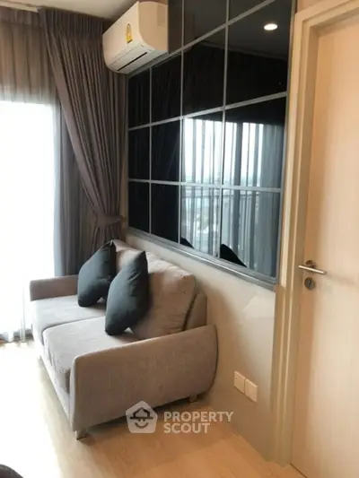Modern living room with stylish sofa and large window, featuring elegant curtains and air conditioning.