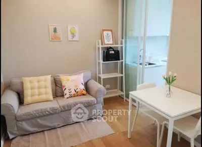 Cozy living room with modern decor and compact kitchen in open layout apartment.