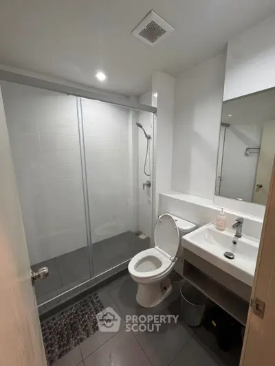 Modern bathroom with glass shower and sleek fixtures in a contemporary home.