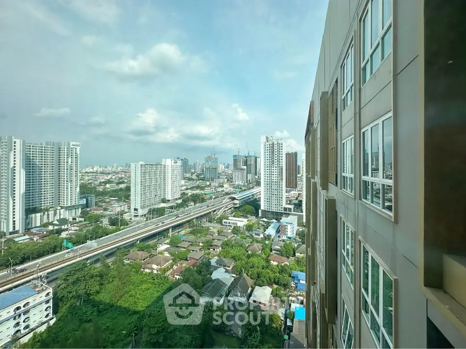 Stunning cityscape view from high-rise building with lush greenery and modern skyline.