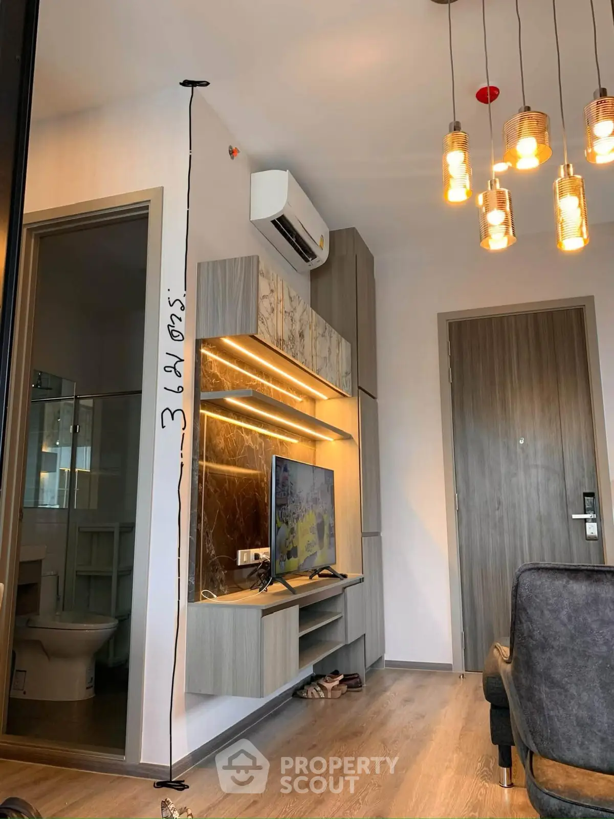 Modern living room with stylish lighting and wall-mounted TV in a cozy apartment.