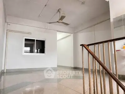 Spacious interior with ceiling fan and staircase, ideal for versatile living arrangements.