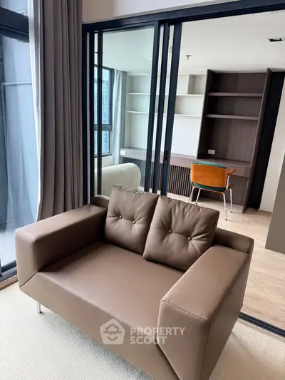 Modern living room with stylish sofa and study area, featuring floor-to-ceiling windows and sleek design.