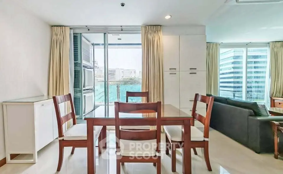 Modern dining area with glass table and city view in a high-rise apartment