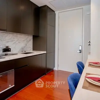 Modern kitchen with sleek cabinetry and marble backsplash in a stylish apartment.