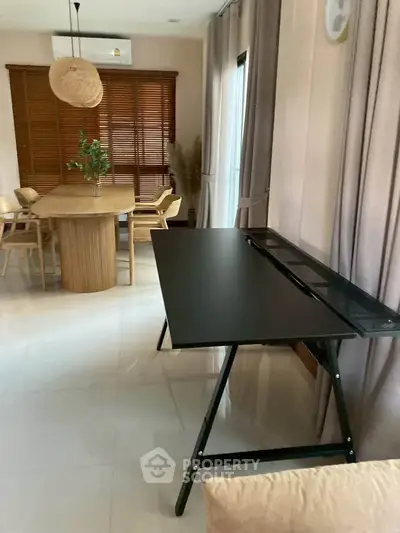 Modern dining area with sleek black desk and wooden table, perfect for stylish home living.