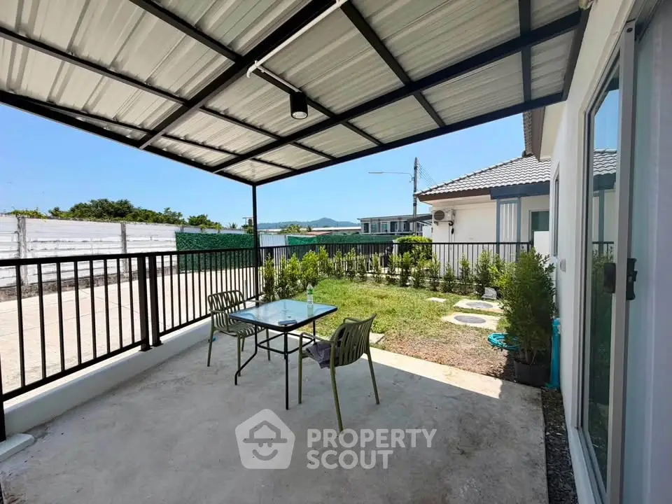 Charming patio with garden view in modern home, perfect for outdoor relaxation and entertainment.