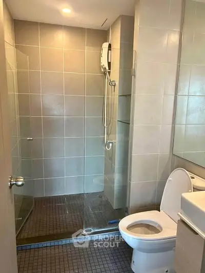Modern bathroom with glass shower enclosure and sleek tile design.