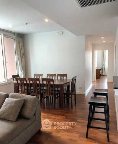 Spacious living room with dining area and wooden flooring in modern apartment