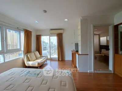Spacious bedroom with large windows and ensuite bathroom in modern apartment