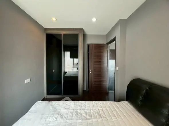 Modern bedroom with sleek design and mirrored wardrobe