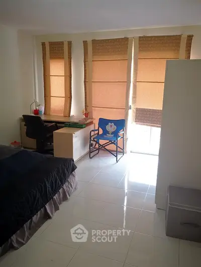 Cozy bedroom with study area and natural light from large windows