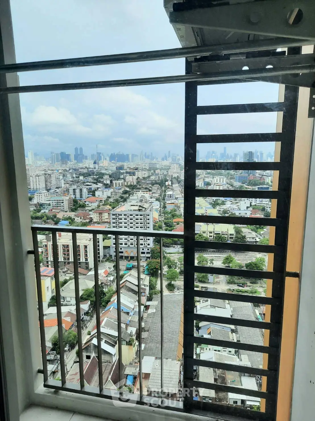 Stunning cityscape view from a high-rise balcony, showcasing urban skyline and vibrant neighborhood.