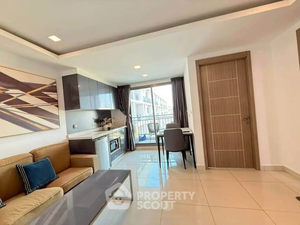 Modern living room with open kitchen and balcony view in stylish apartment.