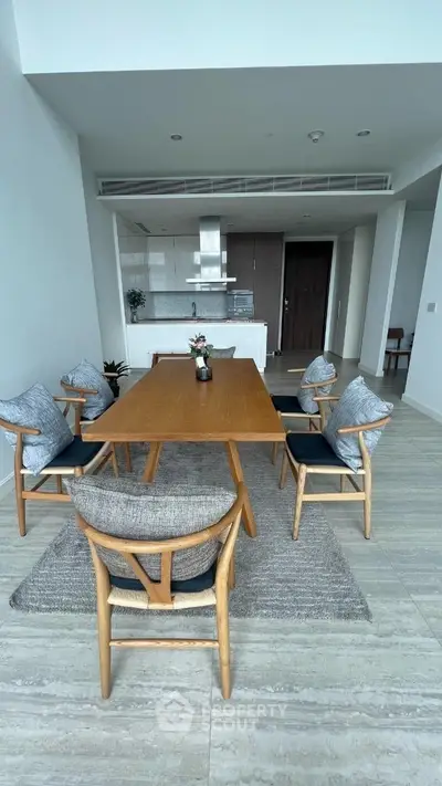 Spacious modern dining area seamlessly integrates with an open-plan kitchen, featuring elegant furniture, sleek finishes, and a welcoming atmosphere perfect for entertaining.
