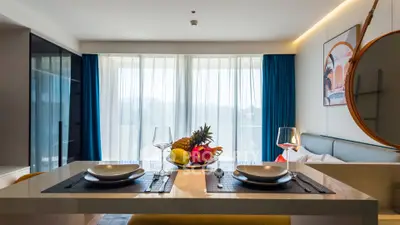 Modern open-plan living room with dining area, large windows, and stylish decor.