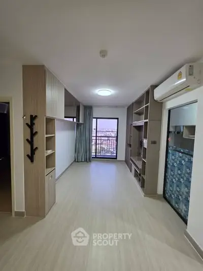 Spacious modern living room with balcony and built-in storage, featuring sleek design and natural light.