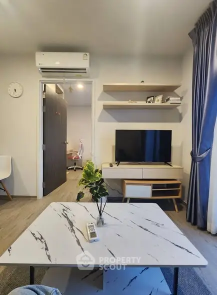 Modern living room with marble coffee table and wall-mounted TV, featuring stylish decor.