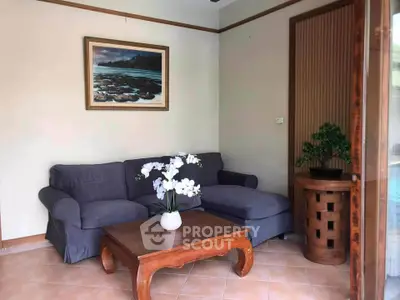 Cozy living room with elegant sofa and wooden coffee table, perfect for relaxation.