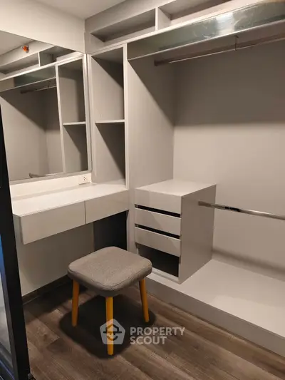 Spacious walk-in closet with modern shelving and seating in a stylish home.