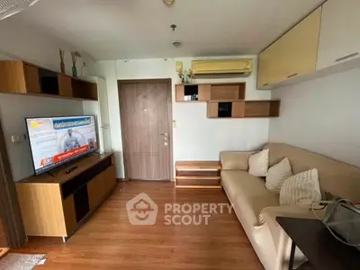 Cozy living room with modern furniture and wall-mounted TV in a stylish apartment.