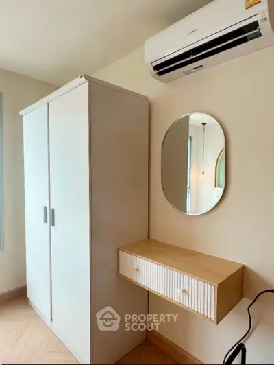 Modern bedroom with sleek wardrobe and wall-mounted air conditioner