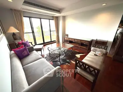 Spacious living room with elegant furniture and large windows offering city views.