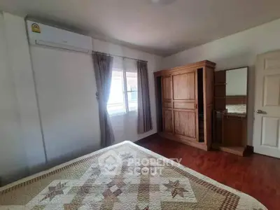 Cozy bedroom with wooden wardrobe and air conditioning, perfect for relaxation.