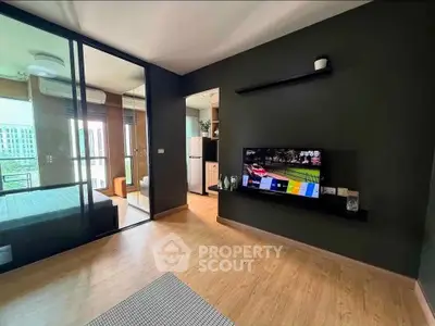 Modern living room with sleek design and open layout, featuring a wall-mounted TV and glass partition.