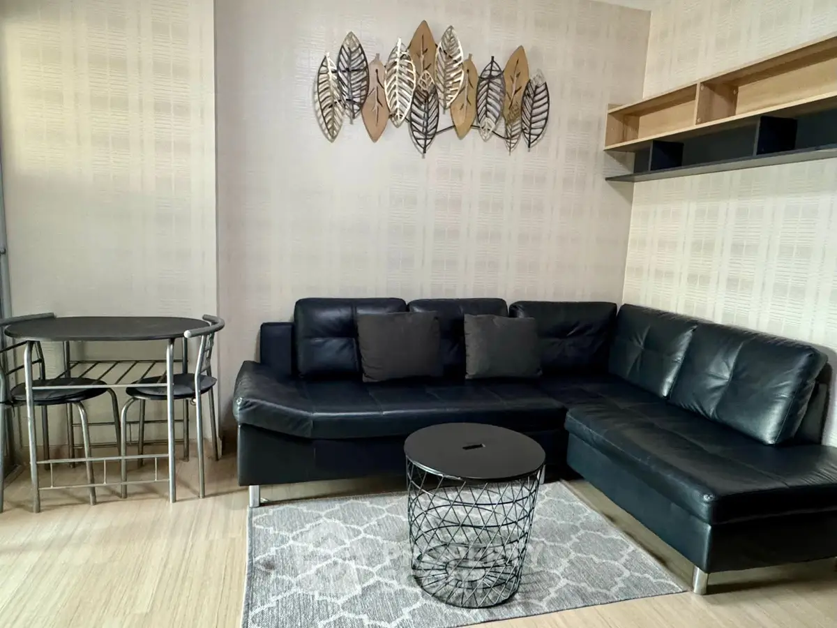 Modern living room with stylish black leather sofa and decorative wall art