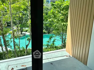Stunning view of lush greenery and pool from a modern balcony, perfect for relaxation.