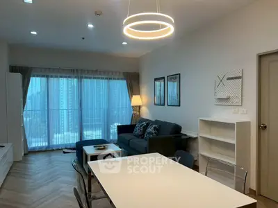 Modern living room with city view, stylish decor, and ample natural light.