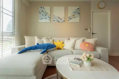 Charming living room with plush sofa, playful decor, and natural light.