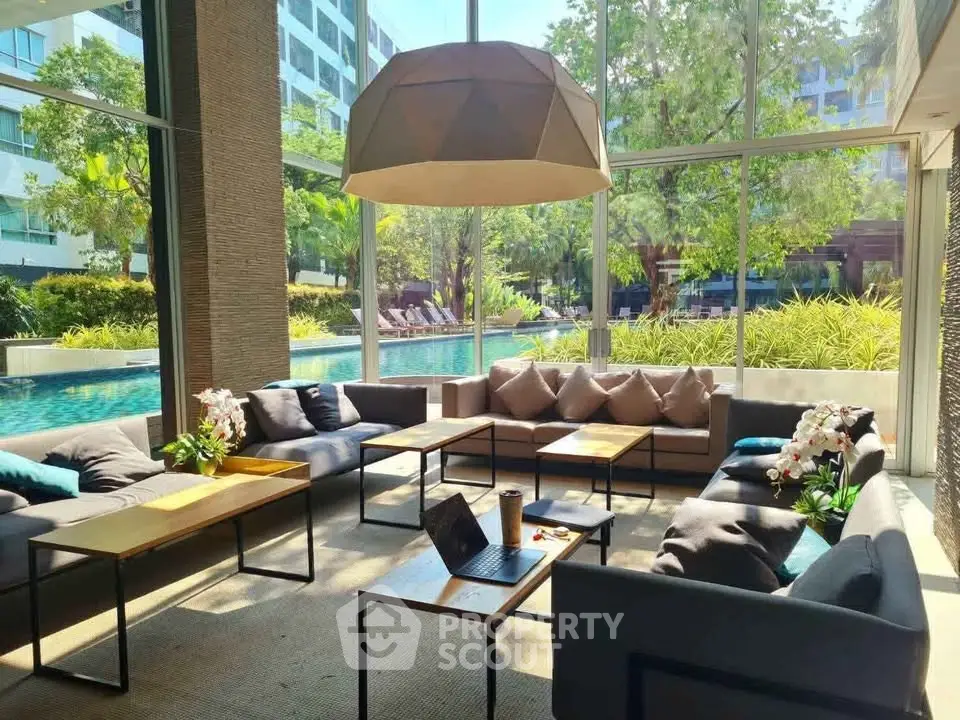 Luxurious poolside lounge with modern seating and lush garden views in a high-end residential complex.