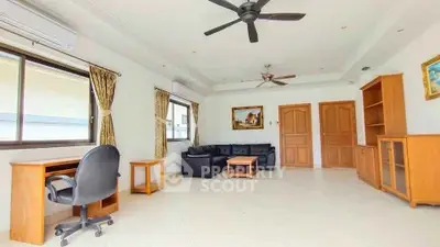Spacious living room with elegant furnishings and ceiling fans, ideal for comfort and style.