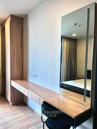 Modern bedroom with sleek wooden desk and large mirror, perfect for a stylish and functional living space.