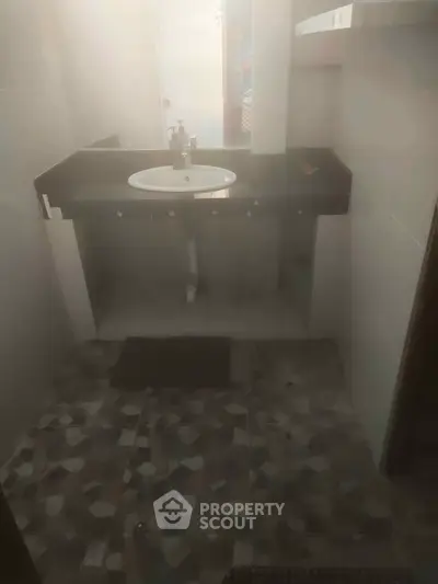 Compact bathroom with modern sink and unique tile flooring