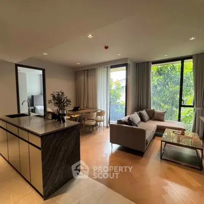 Luxurious open-plan living room with modern kitchen and lush garden view.