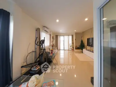 Spacious living room with modern decor and exercise equipment, perfect for relaxation and fitness.