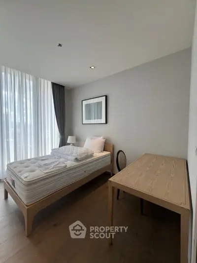 Modern minimalist bedroom with natural light and wooden furniture