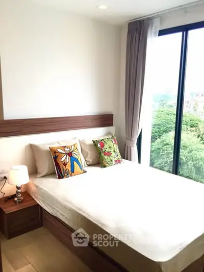 Bright bedroom with large window and stylish decor in modern apartment