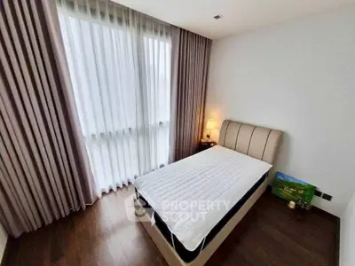 Cozy bedroom with elegant curtains and soft lighting, perfect for relaxation.