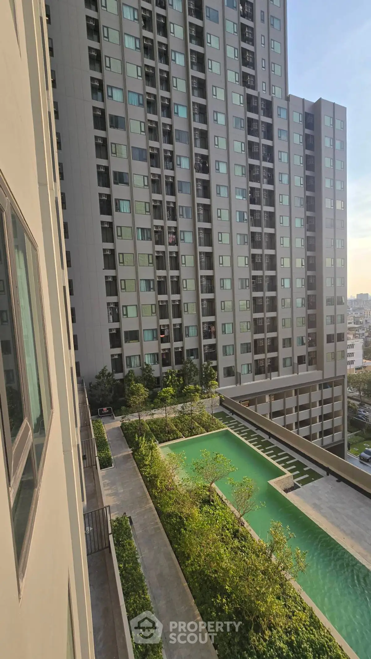 Modern high-rise apartment with pool and lush greenery view