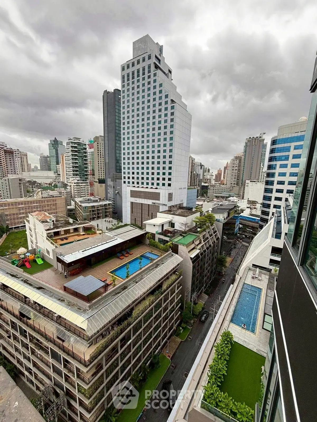 Stunning cityscape view showcasing modern high-rise buildings and rooftop pools in an urban setting.