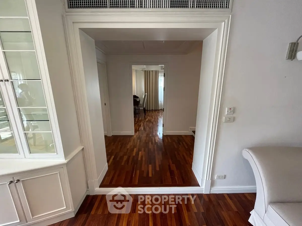 Spacious interior with elegant wooden flooring and stylish white cabinetry, perfect for modern living.