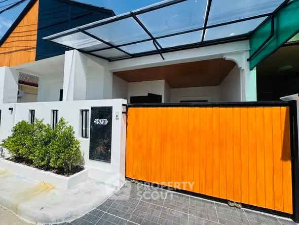 Modern house exterior with sleek design and vibrant orange gate