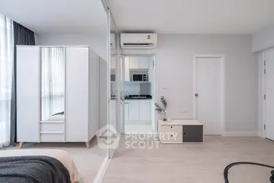 Modern bedroom with mirrored wardrobe and compact kitchen area