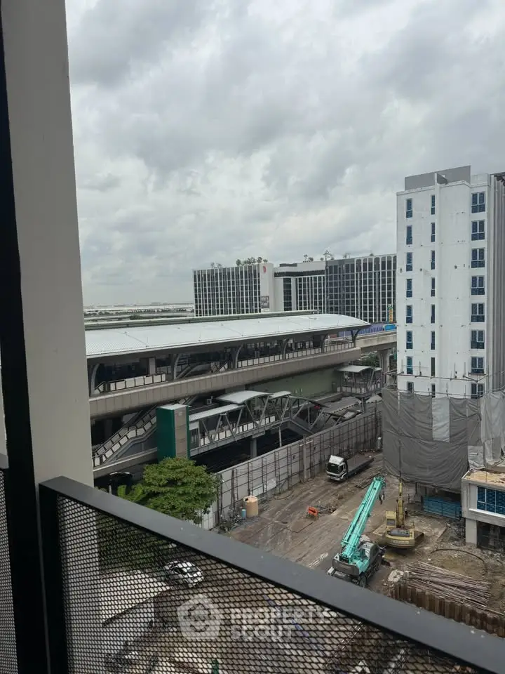 Urban view from balcony overlooking construction and transit station