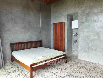 Spacious bedroom with rustic concrete walls and patterned tile flooring